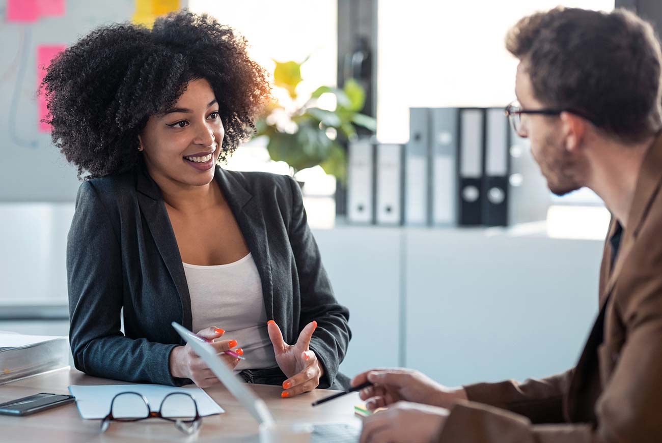 Two female business professionals have a one-on-one meeting to discuss topics on detail