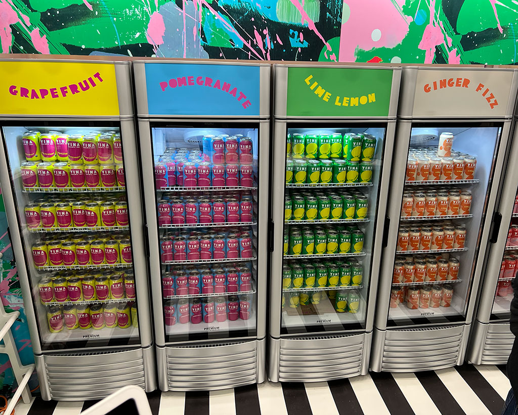 Brightly colored cans of soda arranged on a display shelf