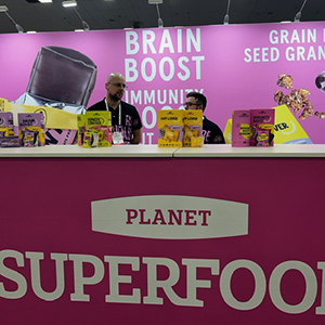 Expo West Tradeshow booth - with team members standing behind a pink booth