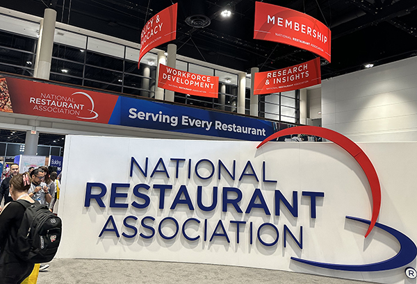 Sign in front of the NRA food show that says National Restaurant Association in blue text on a white background