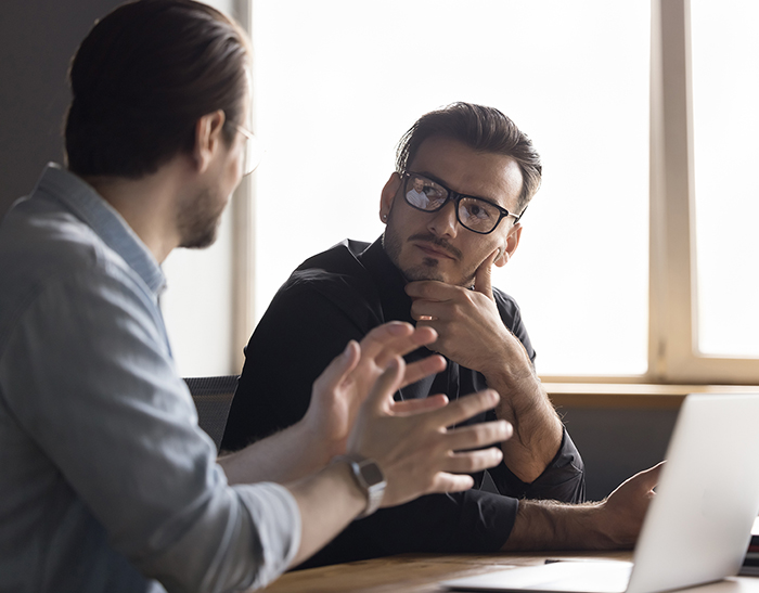 Two speakers turned to speak to each other, both with dark hair