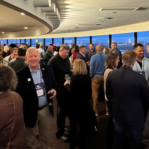 large room of people enjoying cocktails and conversations a the WISE Happy Hour at the PLMA 2023 tradeshow