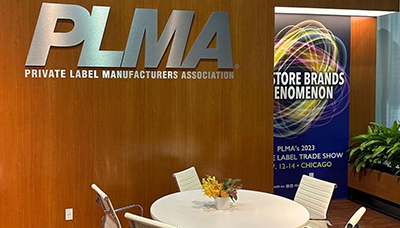 Empty table and chairs in a modern wood booth at the PLMA 2023 tradeshow
