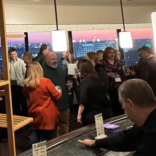large room of people enjoying cocktails and conversations a the WISE Happy Hour at the PLMA 2023 tradeshow