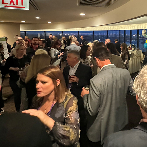large room of people enjoying cocktails and conversations a the WISE Happy Hour at the PLMA 2023 tradeshow