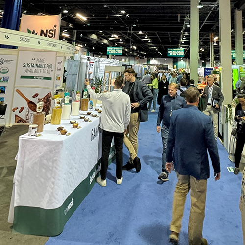 multiple patrons walk on blue carpet at the PLMA 2023 tradeshow