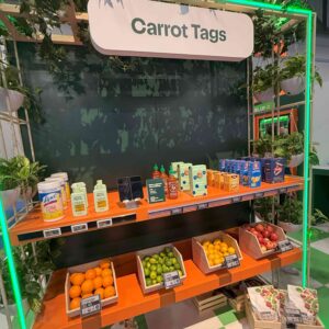 Digital shelf labels on an orange shelf with groceries on the shelf