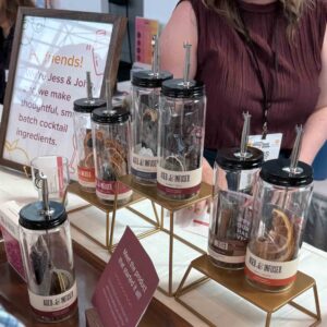 bottle of dried ingredients to make cocktails displayed on a bronze stand