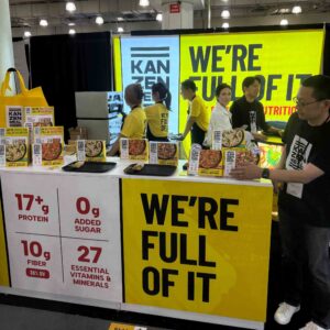 Yellow and white tradeshow booth featuring employees in yellow, white and black shirts.