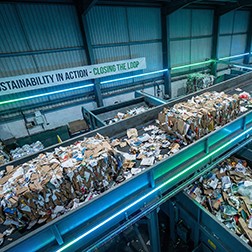 Conveyor belt with moving cardboard waste in recycling facility