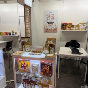 Booth display of 'AUNO GRANO' cereal in pouches and bowls beneath a sign reading 'The world first Hangul Cereal'.